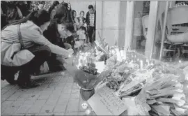  ?? Marta Perez
European Pressphoto Agency ?? FLOWERS AND CANDLES are left at the Joan Fuster secondary school in Barcelona, Spain, after a student attacked teachers and fellow pupils.