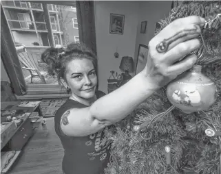 ?? ERIC WYNNE • THE CHRONICLE HERALD ?? Eliese Mackinnon holds up one of her favourite Christmas ornaments as she starts to decorate the tree at her mother’s on Monday. Mackinnon said COVID-19 has exacerbate­d her pre-existing mental health conditions.