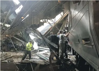  ?? PANCHO BERNASCONI / GETTY IMAGES ?? Train personnel survey the NJ Transit train that crashed into the platform at the Hoboken Terminal on Thursday. The train ran off the end of its track as it approached the station, smashing through a concrete-and-steel bumper.