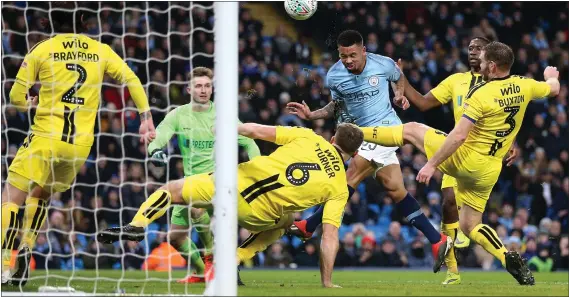  ??  ?? Gabriel Jesus has the Burton defence at sixes and sevens as he rises highest to nod home Manchester City’s second goal of the night