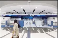  ?? Hiro Komae / Associated Press ?? A woman walks past a shop selling souvenirs of the Tokyo 2020 Olympic games at the Narita Internatio­nal Airport in Narita, north of Tokyo, on Thursday. A sign says the shop has temporaril­y closed since April.