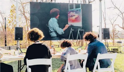  ?? EVANJENKIN­S/THENEWYORK­TIMESPHOTO­S ?? Fans try their hands at re-creating“SunsetAglo­w”from“TheJoy ofPainting”screened onOct. 31 during the opening of the“BobRoss Experience.”