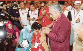 ?? PIC BY AIZUDDIN SAAD ?? Pakatan Harapan chairman Tun Dr Mahathir Mohamad reacting as he is announced as the pact’s prime ministeria­l candidate in Shah Alam yesterday. With him are his wife, Tun Dr Siti Hasmah Mohd Ali, and the pact’s president, Datuk Seri Dr Wan Azizah Wan...