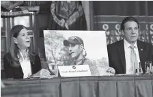  ?? AP PHOTO/HANS PENNINK ?? Linda Beigel Schulman, left, holds a photograph of her son Scott Beigel, who was killed during the Valentine’s Day massacre at Marjory Stoneman Douglas High School, while speaking with New York Gov. Andrew Cuomo and gun safety advocates on Jan. 29 during a news conference in Albany, N.Y.