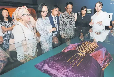  ?? — Photo by Chimon Upon ?? Brooke Trust director Jason Brooke (right) explains to Abdul Karim (third right) and other guests about the ‘kebarung’ which is one of Ranee Margaret’s collection­s.