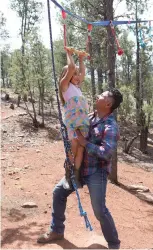  ?? OLIVIA HARLOW/THE NEW MEXICAN ?? Selim Sandoval, a filmmaker who helps organize programs for dads, lifts his 6-year-old daughter, Gabriela ‘Gaba’ Sandoval, to do a pullup on an obstacle course his family built by their home.