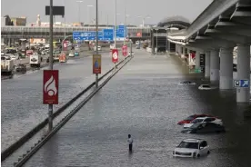  ?? Photograph: Amr Alfiky/Reuters ?? A person stands surrounded by flood water caused by heavy rains, in Dubai, United Arab Emirates, on Wednesday. There was also chaos reported at Dubai Internatio­nal (DBX).