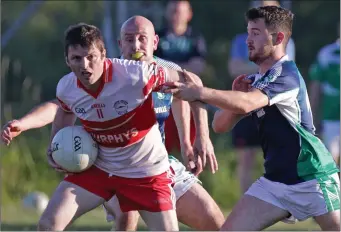  ??  ?? Tommy Boland of Kilanerin under pressure from Volunteers duo Stephen Burke and Mikey Lawlor in the All-County Football League Division 4 semi-final in Páirc Charman on Friday.