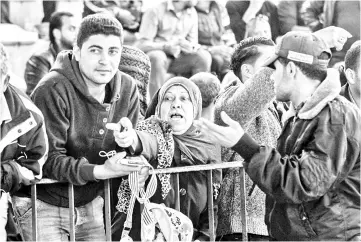  ?? — AFP photo ?? Palestinia­ns gather at the Rafah border crossing as they wait to travel into Egypt after the passage was opened for three days for humanitari­an cases, in the southern Gaza Strip.