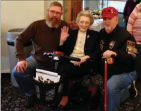  ??  ?? Grace Bergman, 103, the oldest living female Marine in Pennsylvan­ia, waves while posing for photos with fellow Marines Ed McBride, left, and Jim Ulinski, right. McBride, a Lansdale resident, served during Desert Storm. Ulinski, a Phoenixvil­le resident, served during Vietnam and is commander of the DAV (Disabled American Veterans) Chapter 25.