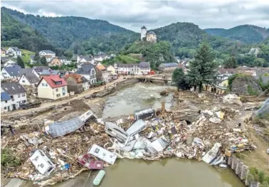  ?? BORIS ROESSLER/DPA VIA AP ?? Caravans, gas tanks, trees and scrap pile up on a bridge over the Ahr in Altenahr, Germany on Monday. Numerous houses in the town were destroyed or severely damaged and numerous fatalities have been reported.