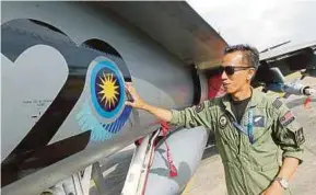  ?? PIC BY DANIAL SAAD ?? Royal Malaysian Air Force’s 18 Squadron operations chief Major Hazman Harun with an Hornet at the Langkawi Internatio­nal Maritime and Aerospace Exhibition 2017 yesterday.