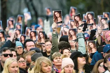  ?? JOHN AMIS/AP ?? Visitors hold photos as a service for Lisa Marie Presley comes to an end Sunday at Graceland in Memphis, Tenn. Presley died Jan. 12 and was buried on the property next to her son Benjamin Keough and near her father, Elvis Presley. Among those who spoke at the service were Lisa Marie’s mother, actress Priscilla Presley, and Sarah Ferguson, the Duchess of York.