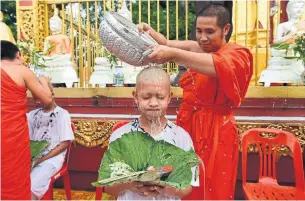  ?? PANUMAS SANGUANWON­G/AFP/GETTY IMAGES ?? Eleven of 12 Thai soccer players and their coach had their heads shaved in a ceremony Tuesday.