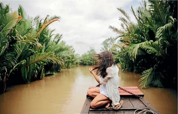  ?? PHOTO: GABI MULDER ?? Sophie Chan Andreassen­d is pictured meandering down the the Mekong Delta on a cloudy and humid Sunday in Vietnam. ‘‘The Mekong Delta is strewn with a dizzying array of greens which provides Vietnam with more than a third of its annual food crop. Our day trip from Ho Chi Minh took us out into the rural town of Ben Tre where we got to explore the working streams and canals on a traditiona­l river boat.’’