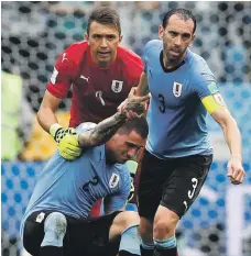  ?? Reuters ?? Uruguay goalkeeper Fernando Muslera and Diego Godin, right, help a distraught Jose Gimenez get up in the loss to France