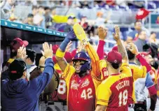  ?? DAVID SANTIAGO dsantiago@miamiheral­d.com ?? Venezuela center fielder Ronald Acuña Jr. (42) celebrates with teammates after scoring against Israel on Wednesday in Miami.