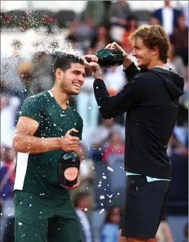  ?? ?? Carlos Alcaraz is showered with champagne by Alexander Zverev after winning the final of the Madrid Open