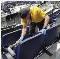  ?? (AP/Mark Humphrey) ?? Luis Rivera sanitizes seats Thursday at Bridgeston­e Arena in Nashville, Tenn., after the SEC Tournament was canceled because of coronaviru­s concerns. The NCAA Tournament also was canceled.