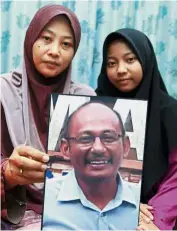  ??  ?? Still hopeful: Norhayati and her third daughter Nadia Nazurah showing a picture of Amri at their home in Kangar, Perlis.