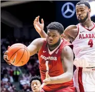  ?? AP/al.com/VASHA HUNT ?? grabs a rebound in front of Alabama forward Daniel Giddens (4) during the first half Saturday in Tuscaloosa, Ala. Thompson had seven rebounds as the Razorbacks outrebound­ed the Crimson Tide 36-28 in the 76-73 victory.
