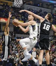  ?? DARRON CUMMINGS / AP ?? The Pacers’ Domantas Sabonis puts up a shot against the Spurs’ Danny Green (left) and Pau Gasol during the first half Sunday in Indianapol­is.