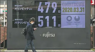  ?? (File Photo/AP/Jae C. Hong) ?? A man walks March 31past a countdown display for the Tokyo 2020 Olympics and Paralympic­s in Tokyo. The countdown clock is ticking again for the Tokyo Olympics. They will be July 23 to Aug. 8, 2021. The clock read 479 days to go.