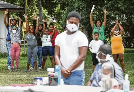  ?? Jon Shapley / Staff file photo ?? Family and friends cheer for Lloyd Nelms, front right, before he signed the final paperwork for his rebuilt home this past May, with funds he got from the state after the city failed to repair his home.