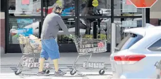  ?? RICARDO RAMIREZ BUXEDA/ORLANDO SENTINEL ?? A shopper wears a mask in April outside the Publix at 10250 Curry Ford Road. Customers at the more than 1,250 Publix stores across the Southeast will be required to wear face coverings starting Tuesday.