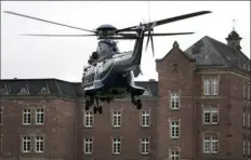  ?? Associated Press ?? A police helicopter with a suspect arrives in Karlsruhe, Germany, on Wednesday close the federal prosecutor's office. Officials said 25 people were detained.