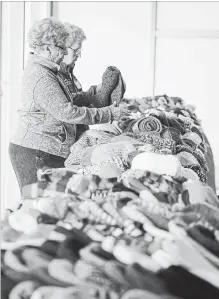  ?? SCOTT GARDNER THE HAMILTON SPECTATOR ?? Volunteers Eleanor Petrovsky, left, and Bernice Jacobs sort through woolen hats, scarves and mittens at the marketplac­e Friday.