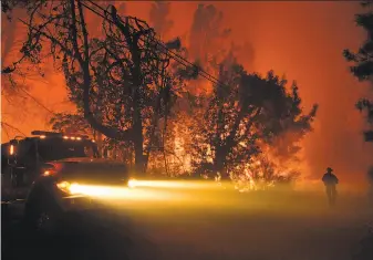  ?? Josh Edelson / AFP / Getty Images ?? A firefighte­r surveys a hot spot in the Santa Cruz Mountains near Loma Prieta. The fire burned at least 2,250 acres and several structures, but no injuries had been reported.