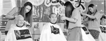  ??  ?? Chong (left) and three other participan­ts were the first to have their heads shaved at I-Shave 6.0.