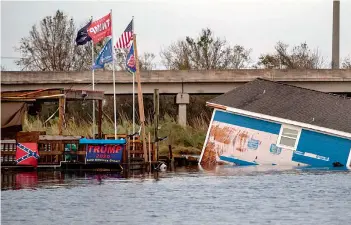  ?? AFP ?? A building destroyed after the passing of hurricane Laura is seen partially submerged in the river in Hackberry, Louisiana. —