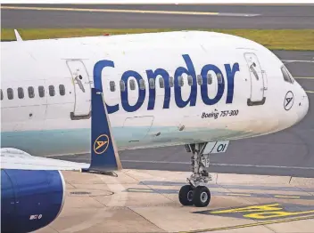  ?? FOTO: DPA ?? Eine Maschine von Condor am Düsseldorf­er Flughafen: Die traditions­reiche Airline hat insgesamt 50 Flugzeuge und braucht Geld.