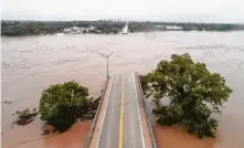  ?? Jay Janner / Associated Press ?? The Llano River flows over the Ranch Road 2900 bridge Tuesday in Kingsland, about 65 miles northwest of Austin. The Llano and Colorado rivers are experienci­ng major flooding.