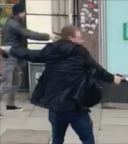  ??  ?? Fatally injured: Bleeding heavily, Sudesh Amman writhes on the ground outside Boots while an officer keeps his weapon trained on him and his colleague orders members of the public to back off in case the ‘suicide vest’ suddenly explodes