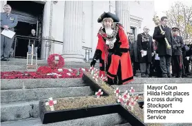  ??  ?? Mayor Coun Hilda Holt places a cross during Stockport Remembranc­e Service