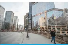  ?? — AFP ?? CHICAGO: In this file photo taken on March 21, 2020 a man walks by Trump Internatio­nal Hotel and Tower in Chicago, Illinois. Donald Trump shot to prominence with a business empire that bears his name, but after four years of political tumult capped by his supporters’ violent attack on the Capitol, the US president’s brand stands tarnished, threatenin­g his businesses, experts say.