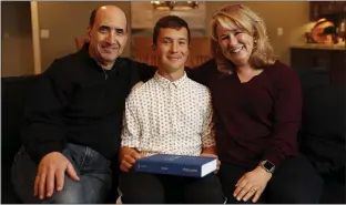  ?? NHAT V. MEYER STAFF PHOTOGRAPH­ER ?? Justin Ball, 13 — with his parents, Larry and Deanne Ball, in their home in San Jose on Sunday — postponed his bar mitzvah at Temple Emanu-El over coronaviru­s concerns.