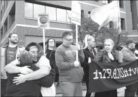  ?? NWA Democrat-Gazette/CHARLIE KAIJO ?? Attendees hold signs, chant and wave at cars during a rally Saturday in front of the Washington County Courthouse in Fayettevil­le.