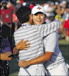  ?? SAM GREENWOOD / GETTY IMAGES ?? Si Woo Kim (right) celebrates Sunday’s Mother’s Day victory at The Players with a hug from his father.