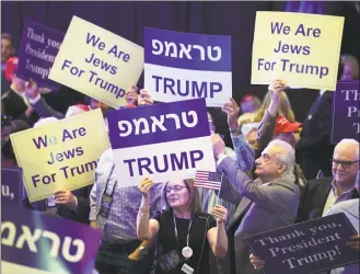  ?? Ethan Miller / Getty Images ?? Attendees hold up signs while waiting to see President Donald Trump speak during the Republican Jewish Coalition’s annual leadership meeting at The Venetian Las Vegas on Saturday in Las Vegas.