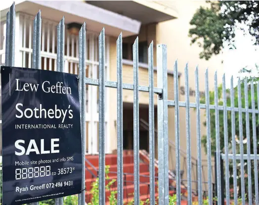  ?? ?? EASIER TO BUY: The Sotheby’s sign board outside a block of flats in Culver Street in Oranjezich­t, Cape Town.