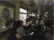 ?? THE ASSOCIATED PRESS ?? This photo provided by Jackie Faherty from her Twitter page shows subway passengers on an A train with the lights out after it halted just shy of the 125th street stop in New York’s Harlem neighborho­od.