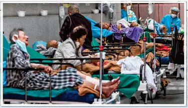  ?? ?? CRISIS ZONE: Covid patients in an overcrowde­d holding area at a Hong Kong hospital