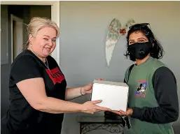  ?? AIMAN AMERUL MUNER/STUFF ?? Annette Howey, left, passes to Jess Grewal the second-to-last cake she made before closing her cake-making business.