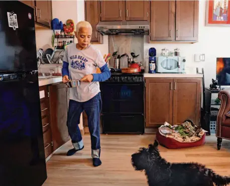  ?? Photos by Lea Suzuki/The Chronicle ?? Margie Talavera feeds her dog, Little Bear, after a walk in the neighborho­od near her home at the Edwin M. Lee Apartments.