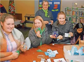  ?? FOTO: HEIKO LEHMANN ?? In der Jugendkirc­he an der Halbergstr­aße bastelten sie am Freitag aus als alten Milchtüten Geldbeutel (am Tisch, von links): Bianca Hirth, Jessica Reuther, Susanne Walzer und Jyoti Shukla.