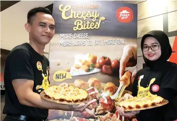  ??  ?? Staff of Pizza Hut Suria Sabah holding the Chicken Cheesy Bites pizzas.